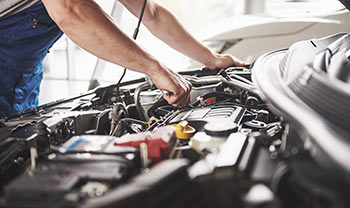 Specialist mechanics repair cars on vehicle lifts in service station garage